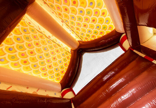 Dach krytego zamku dmuchanego udekorowane jak piernikowy domek w temacie piernika